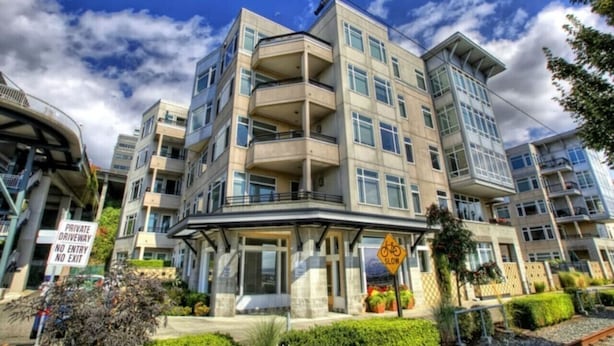 A multi-story residential building with balconies, a private driveway, and a slow sign. - Waterfront 2BD Next to Pike Place w/ Private Patio (Seattle)