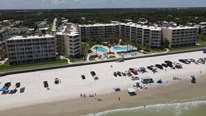 Een resort met meerdere gebouwen, een strand en een zwembad.