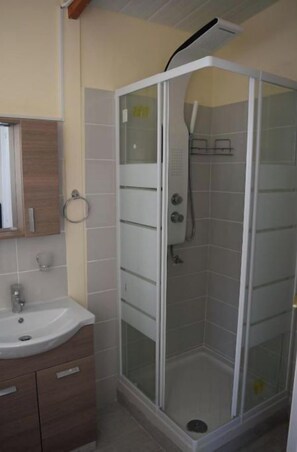 Een bad/douchecombinatie, handdoeken, toiletpapier