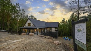 Un chalet doté d’une façade en pierre, d’un porche couvert et d’une allée gravillonnée.