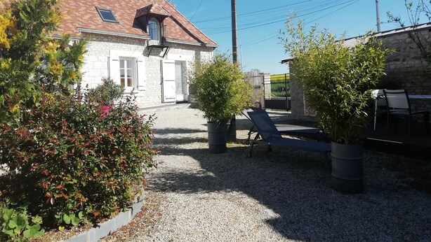 Ein Haus mit Ziegeldach, einem Balkon und einem Schotterweg.