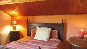 Ein Schlafzimmer mit einem hölzernen Bett, zwei Nachttischlampen und einem kleinen runden Tisch.