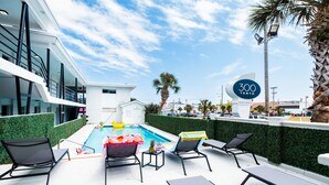 A rooftop pool area with lounge chairs, a pool, and a sign indicating '300 Tenth Myrtle Beach'. - 300 Tenth (Myrtle Beach)