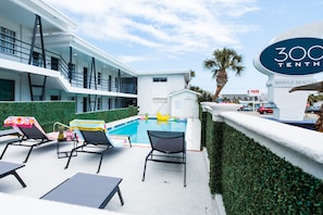 A modern hotel with a rooftop pool, lounge chairs, and a sign indicating '300 Tenth Myrtle Beach'. - 300 Tenth (Myrtle Beach)