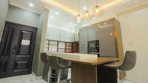 Een moderne keuken met een centraal eiland, roestvrijstalen apparatuur en hanglampen.