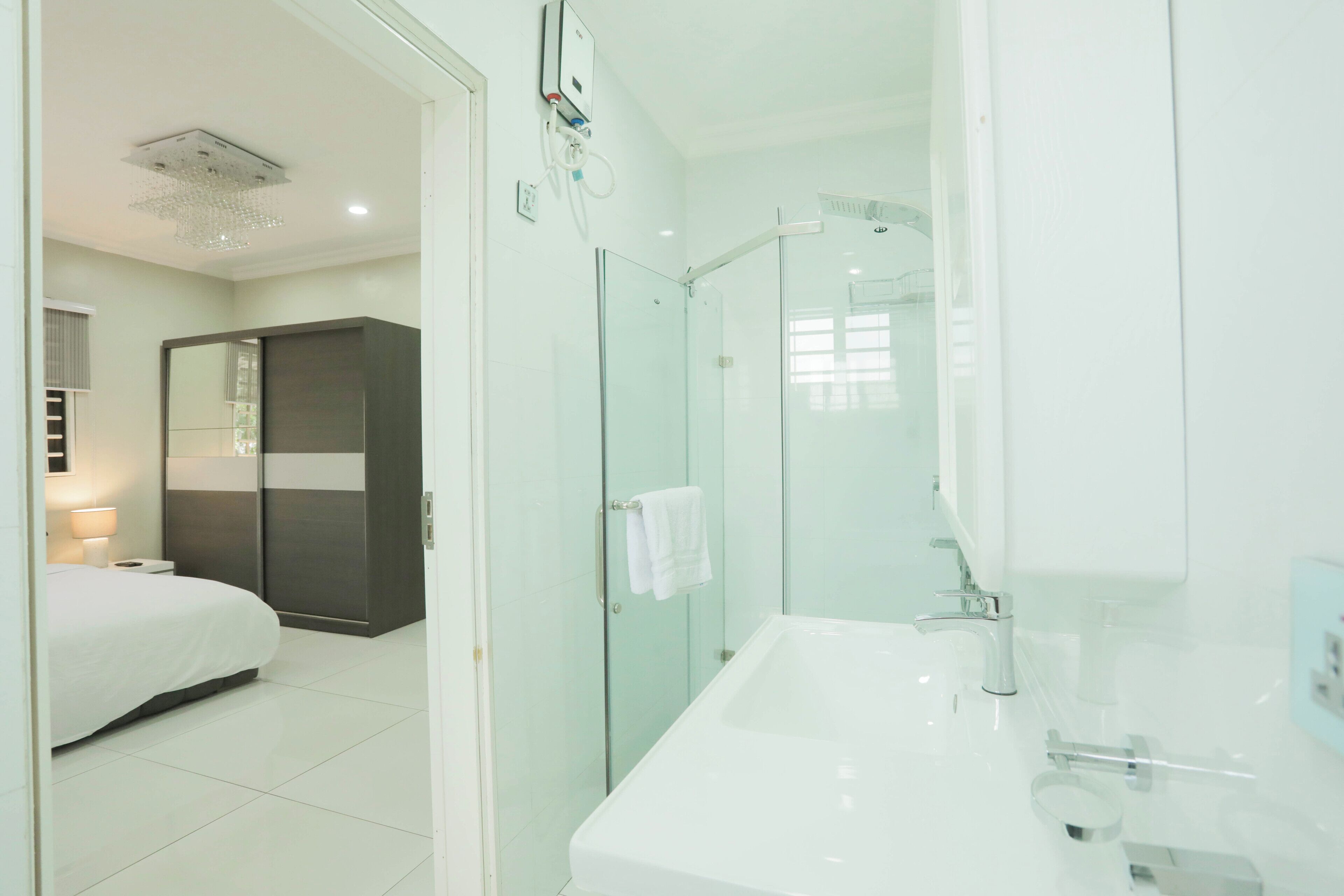 A modern bathroom with a glass shower enclosure, a white sink, and a large mirror.