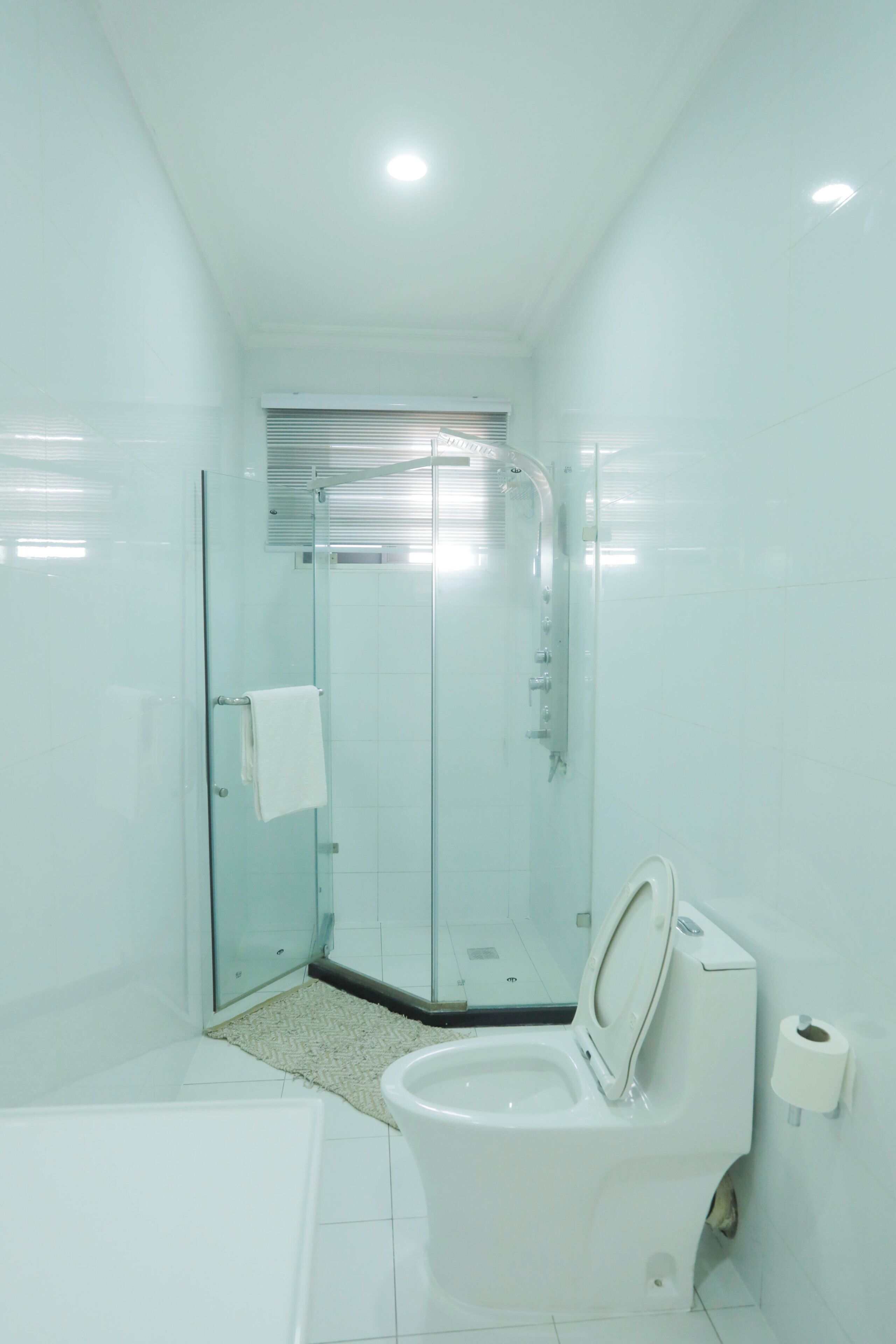 Et moderne badeværelse med bruseniche, toilet og håndvask.