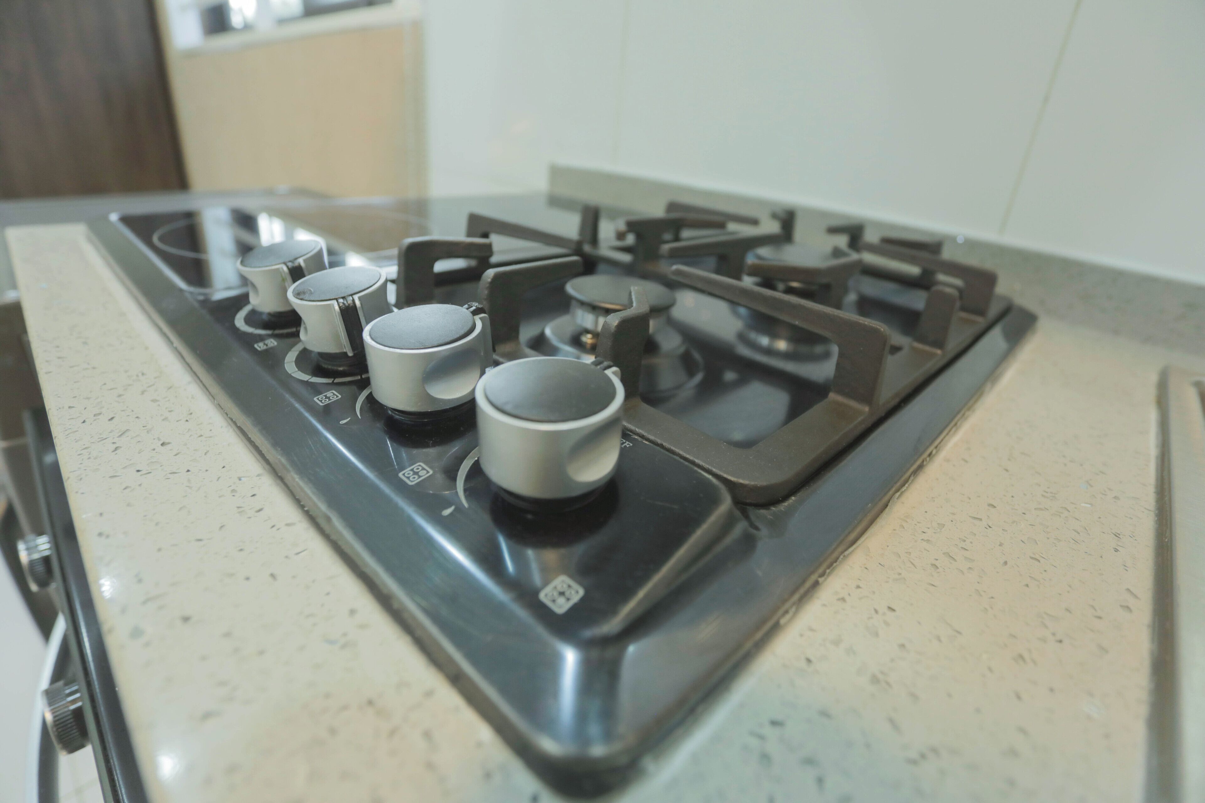 A kitchen with a gas stove and four burners.