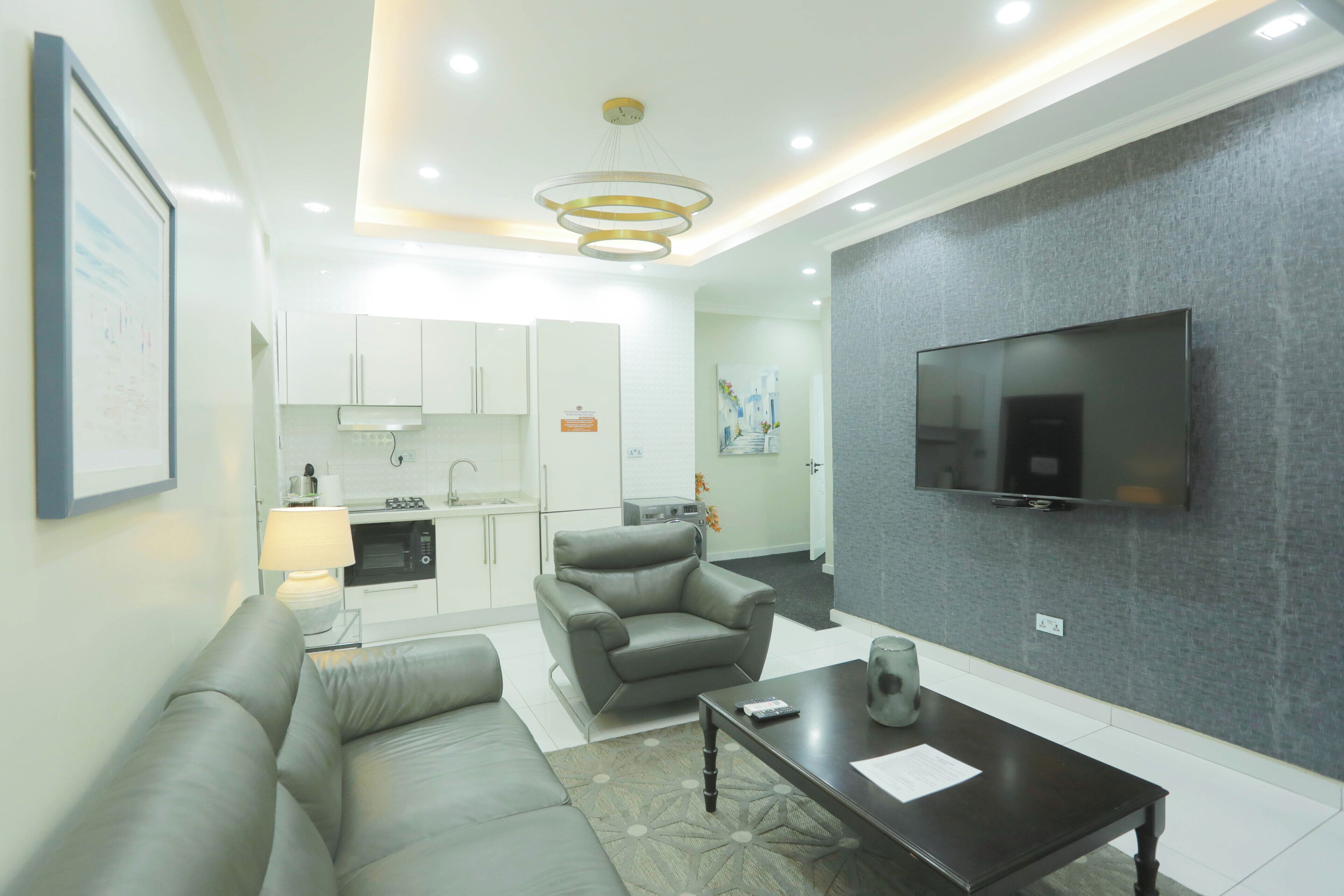 A modern living room with a sofa, a coffee table, and a TV mounted on the wall.