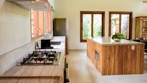 Una cocina moderna con estufa a gas, electrodomésticos de acero inoxidable y armarios de madera.