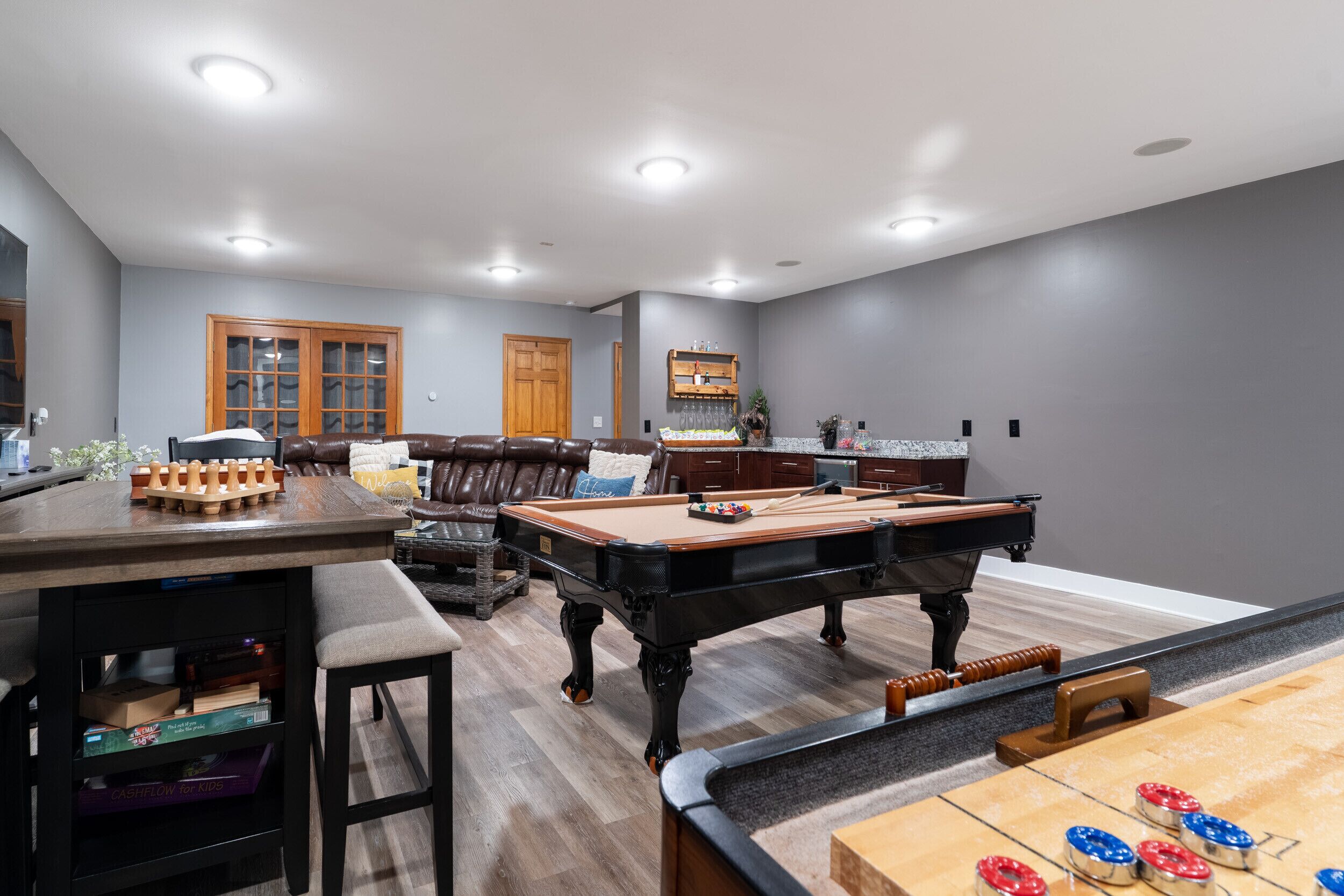 Un salon spacieux équipé d’une table de billard, d’un baby-foot et d’une table de jeu de flipper.
