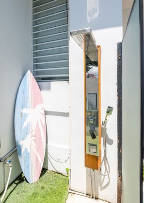 A surfboard leaning against a wall, a metal utility box, and a building with a window and a door. - 5 Bedroom Boho Beach House 30 steps from the beach (San Juan)