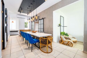 Un comedor moderno con una mesa blanca, sillas azules y sillas de mimbre.