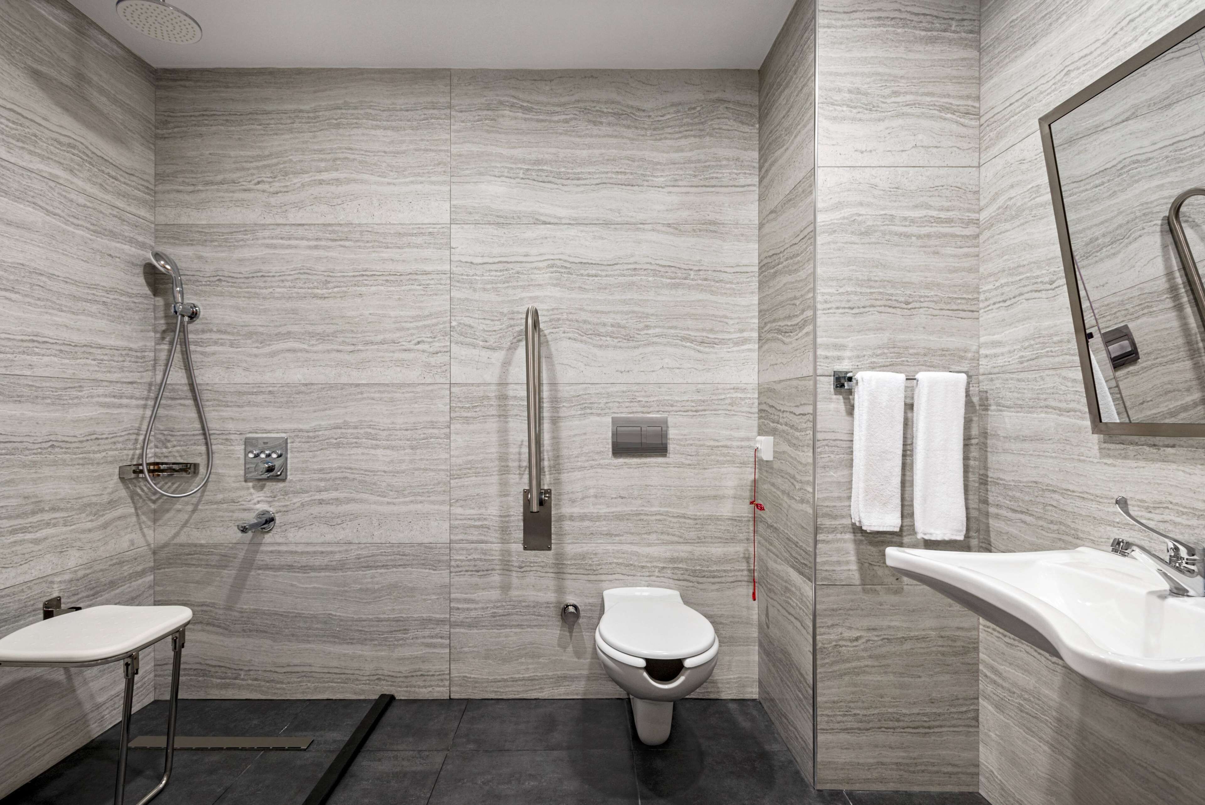 A modern bathroom with a shower, toilet, and sink.