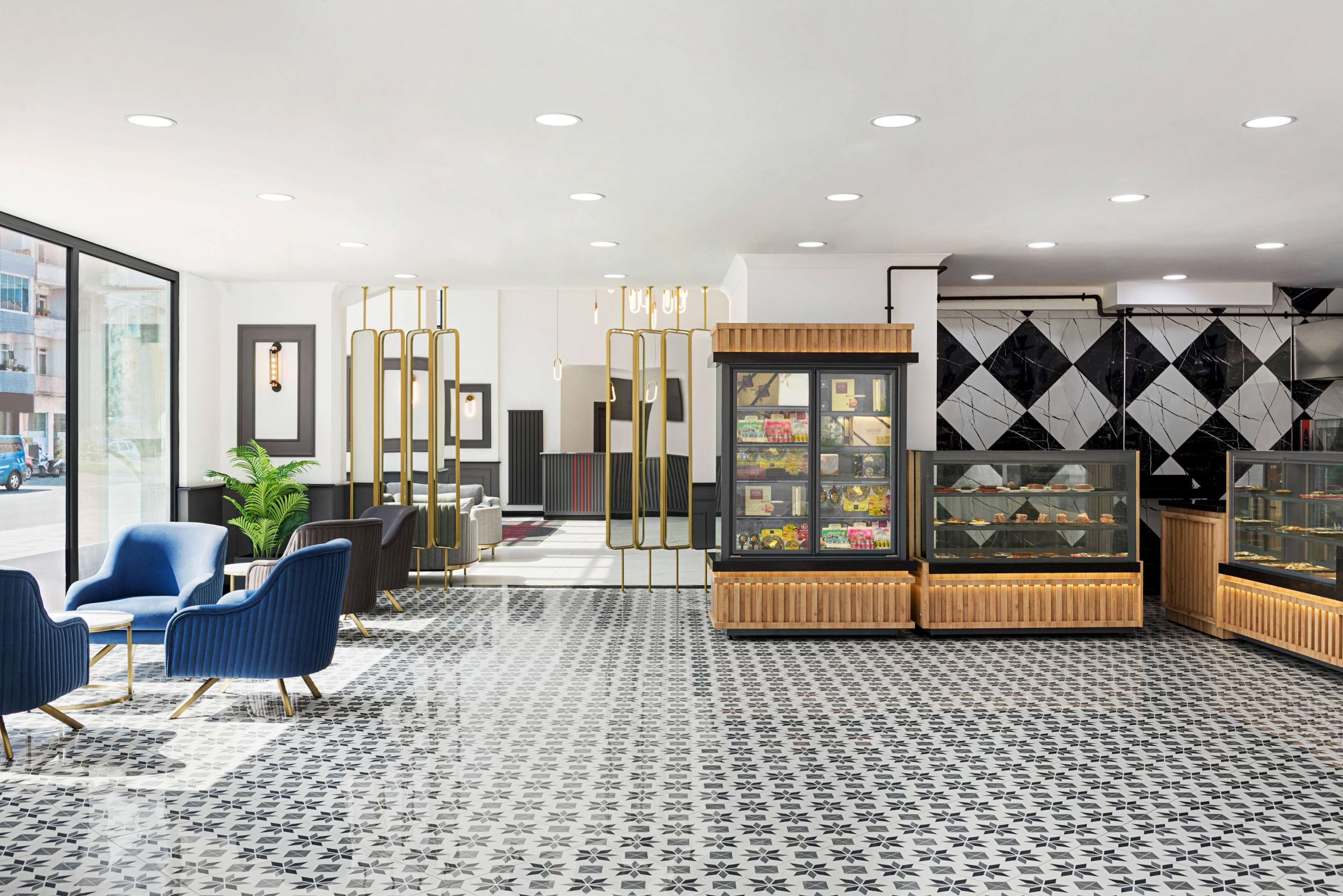 A modern lobby with seating, a plant, and display cases.