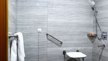 A shower with a handheld showerhead, a handheld shower attachment, and a handheld shower attachment.