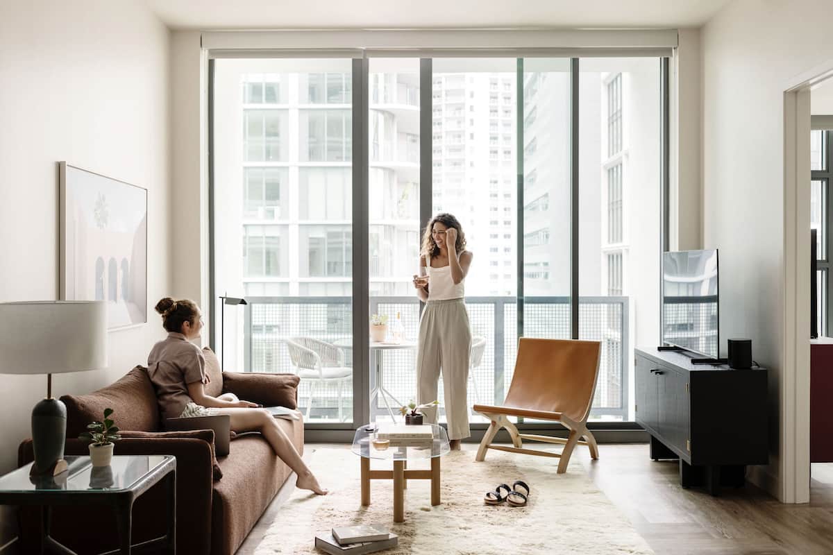 A modern living room with a large window, a sofa, a coffee table, and a chair.