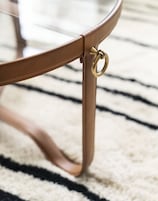 A close-up of a chair's metal frame with a brass ring.