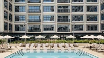 Una piscina al aire libre, camas de piscina gratis, sombrillas