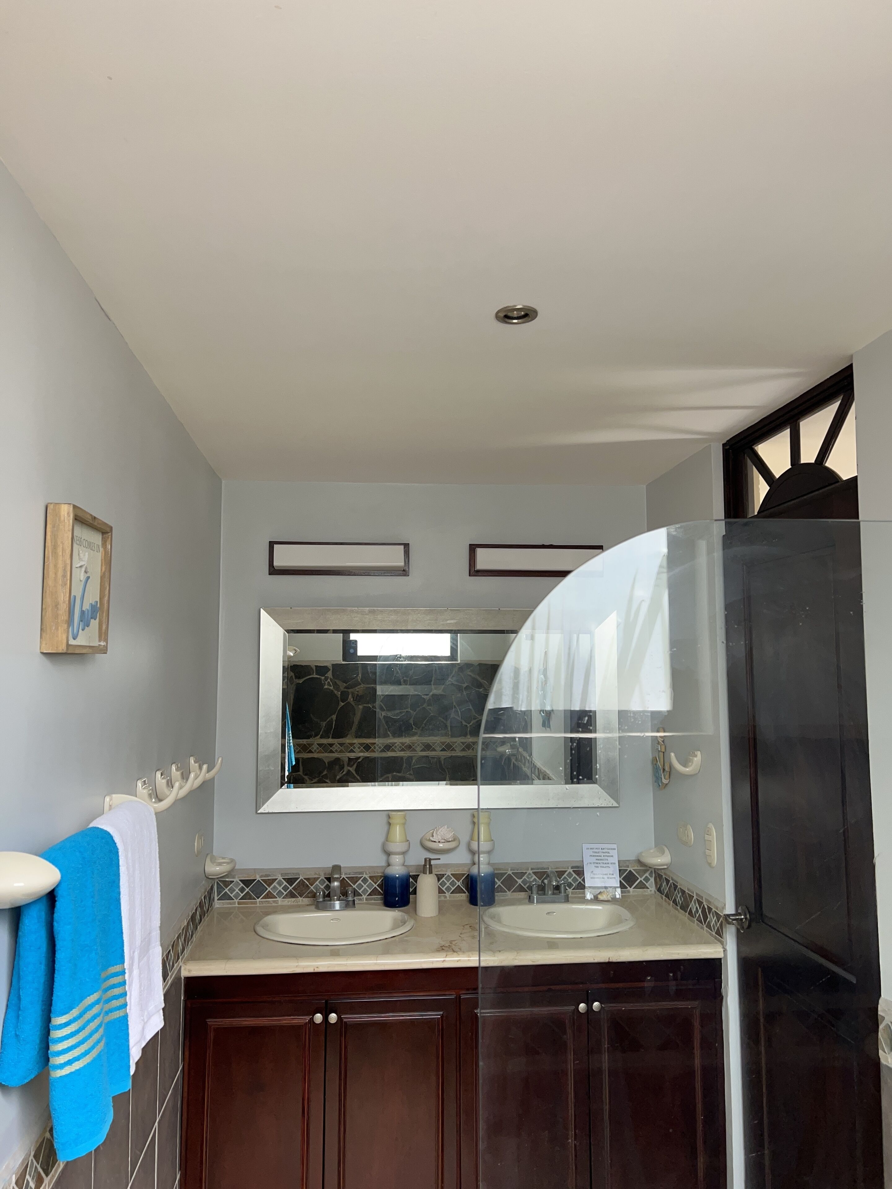 A bathroom with two sinks, a mirror, and a shower area.