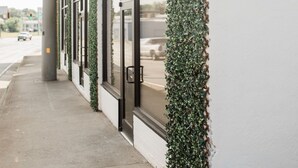 A building with a white exterior, large windows, and a narrow sidewalk. - Luxury loft in historic downtown Tifton, Georgia (Tifton)