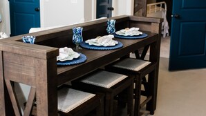 A dining table with blue placemats and a vase, set in a room with blue doors and a framed picture on the wall. - Luxury loft in historic downtown Tifton, Georgia (Tifton)