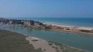 A coastal view with a beach, a calm sea, and a row of buildings along the shore. - House with beautiful view, swimming pool, beach 5 min walk (Dives-sur-Mer)