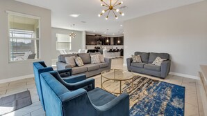 Ein modernes Wohnzimmer mit einem grauen Sofa, blauen Sessel und einem Couchtisch.