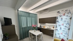 Un espace de vie compact comprenant un coin repas, une kitchenette et un canapé.