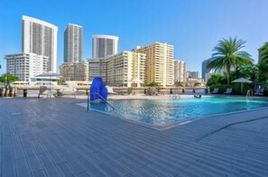 Relax by the pool surrounded by lounge chairs and umbrellas.