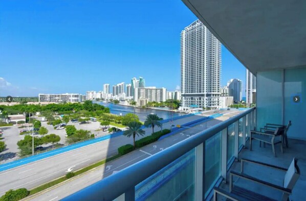 Enjoy the urban view from this hotel's balcony, featuring a seating area with benches and a clear view of the surrounding cityscape.