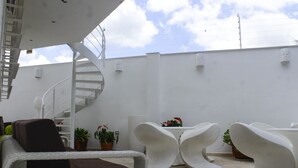 A modern outdoor seating area with white chairs and a spiral staircase. - A house with views in Ccs in a safe area III (Caracas)