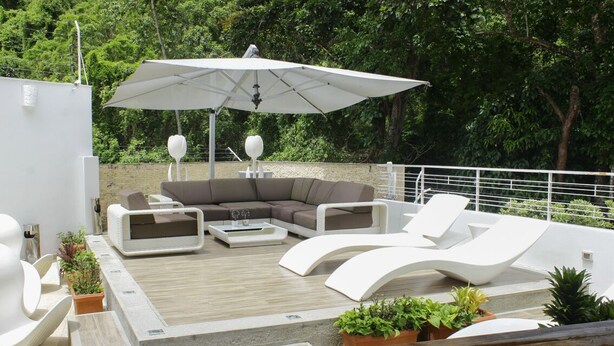 A rooftop terrace with a sectional sofa, lounge chairs, and a coffee table. - A house with views in Ccs in a safe area III (Caracas)