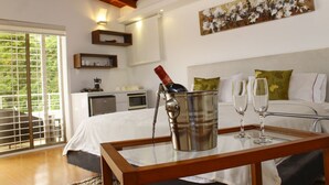 A hotel room with a bed, a bedside table with a bottle and glasses, a painting on the wall, and a balcony with a view. - A house with views in Ccs in a safe area III (Caracas)