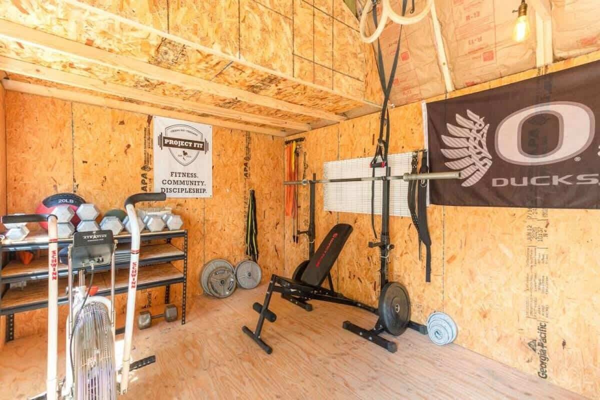 Ett gym med träväggar, utrustning för styrketräning och en banderoll.