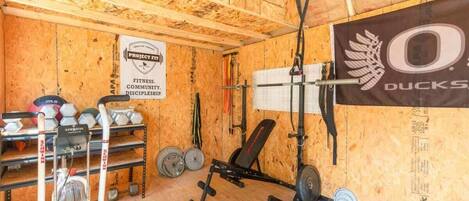 Ett gym med träväggar, utrustning för styrketräning och en banderoll.