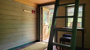 Interior de madera con un cartel de 'No Smoking', un banco de madera y una escalera apoyada en la pared.