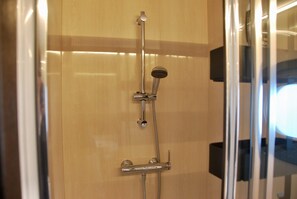 Een douche, handdoeken, toiletpapier