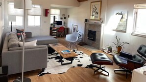 Una sala de estar amplia con chimenea, un sofá, una mesa de centro y un comedor.