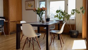 Una cocina moderna con armarios de madera, una mesa de comedor con sillas y ventanas amplias que dejan entrar luz natural.
