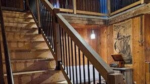 Una scala in legno con ringhiera in metallo che conduce a un'area al secondo piano.