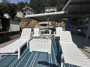 Un espacio al aire libre cubierto con sillones reclinables y una mesa de billar.