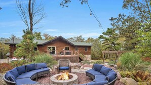 A wooden cabin with a deck, surrounded by outdoor furniture and a fire pit. - Sky Pine Lodge - Chalet Atop the World (Jim Thorpe)