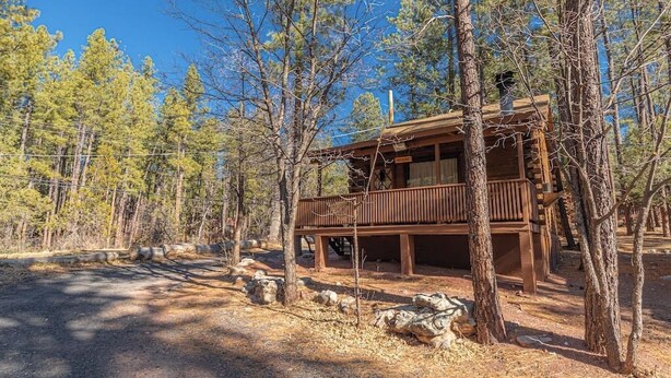 A rustic cabin with a wooden deck, surrounded by trees and a clear sky. - Forest Cabin 5 Old Glory (Payson)