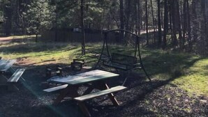 A forested area with a picnic table and benches. - Forest Cabin 1 Hunters Blind (Payson)