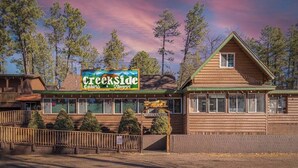 Un edificio de estilo cabaña de madera con un cartel que dice Creekside Cabins & Tavern.