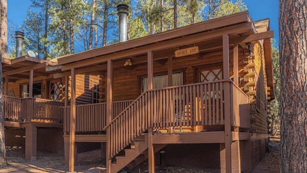 A rustic cabin with a wooden exterior, a covered porch, and a chimney. - Forest Cabin 3 Bear's Den (Payson)