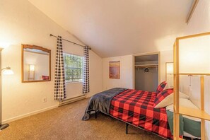A bedroom with a bed, a wardrobe, a mirror, and a window with curtains. - Quaint condo retreat 12 Ridgeview Condo (Payson)
