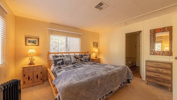 Une chambre confortable avec un grand lit, deux lampes de chevet, une commode et un miroir.