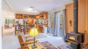 Un vaste espace de vie doté d’une cheminée, de meubles en bois et d’un coin repas.